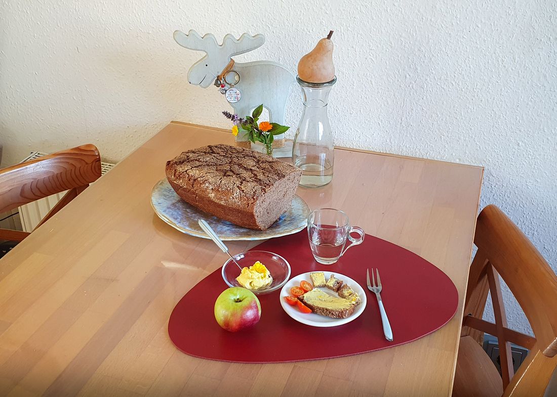 Gedeckter Tisch mit frischem Brot, Apfel, Käse und Tomaten – Frühstück bei den Elchkindern